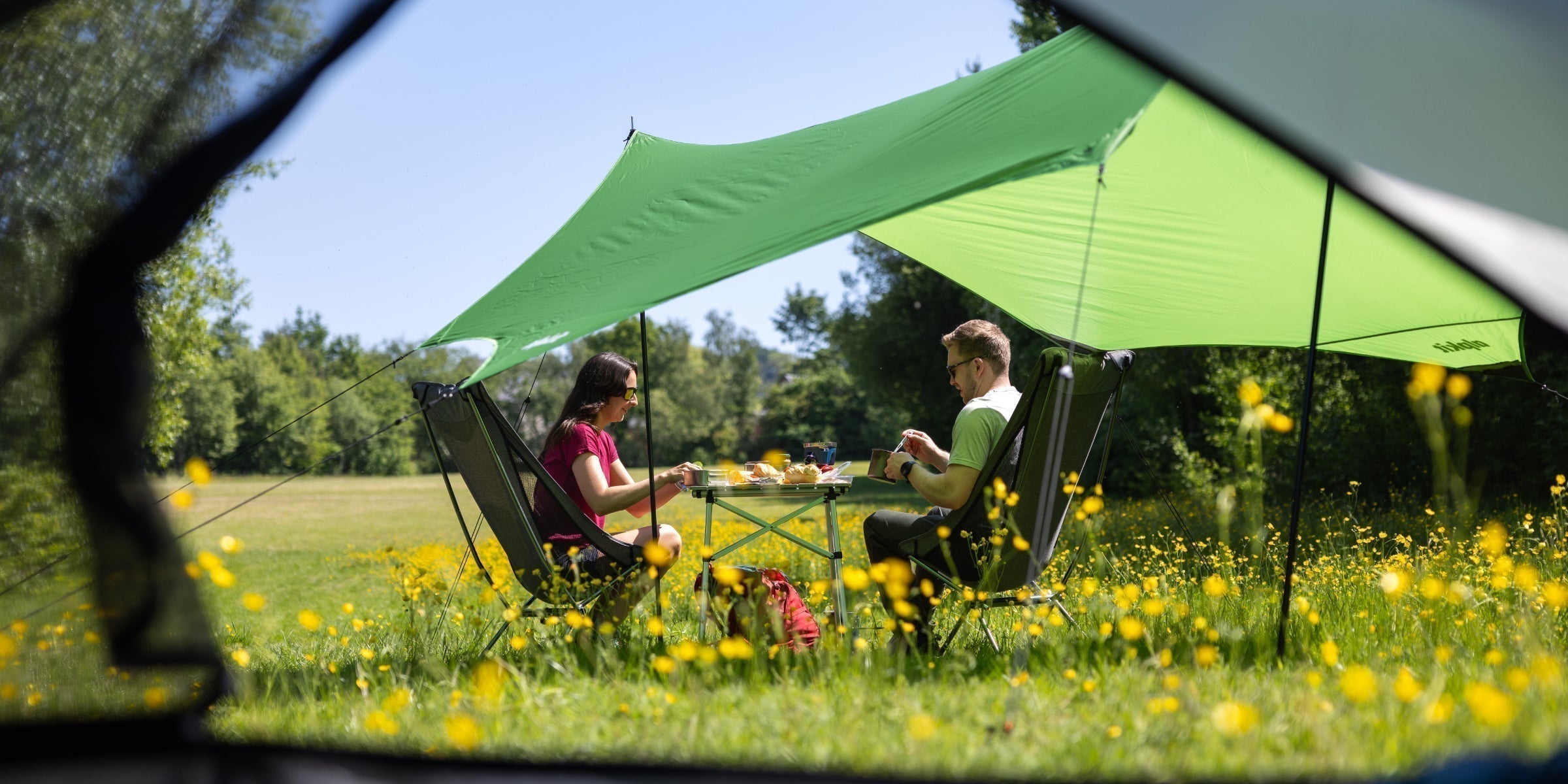 Campers finding shade under a awning