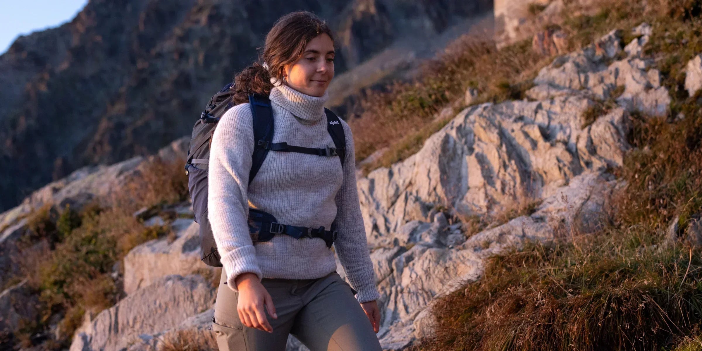 Woman hiking in the mountains in a wool jumper