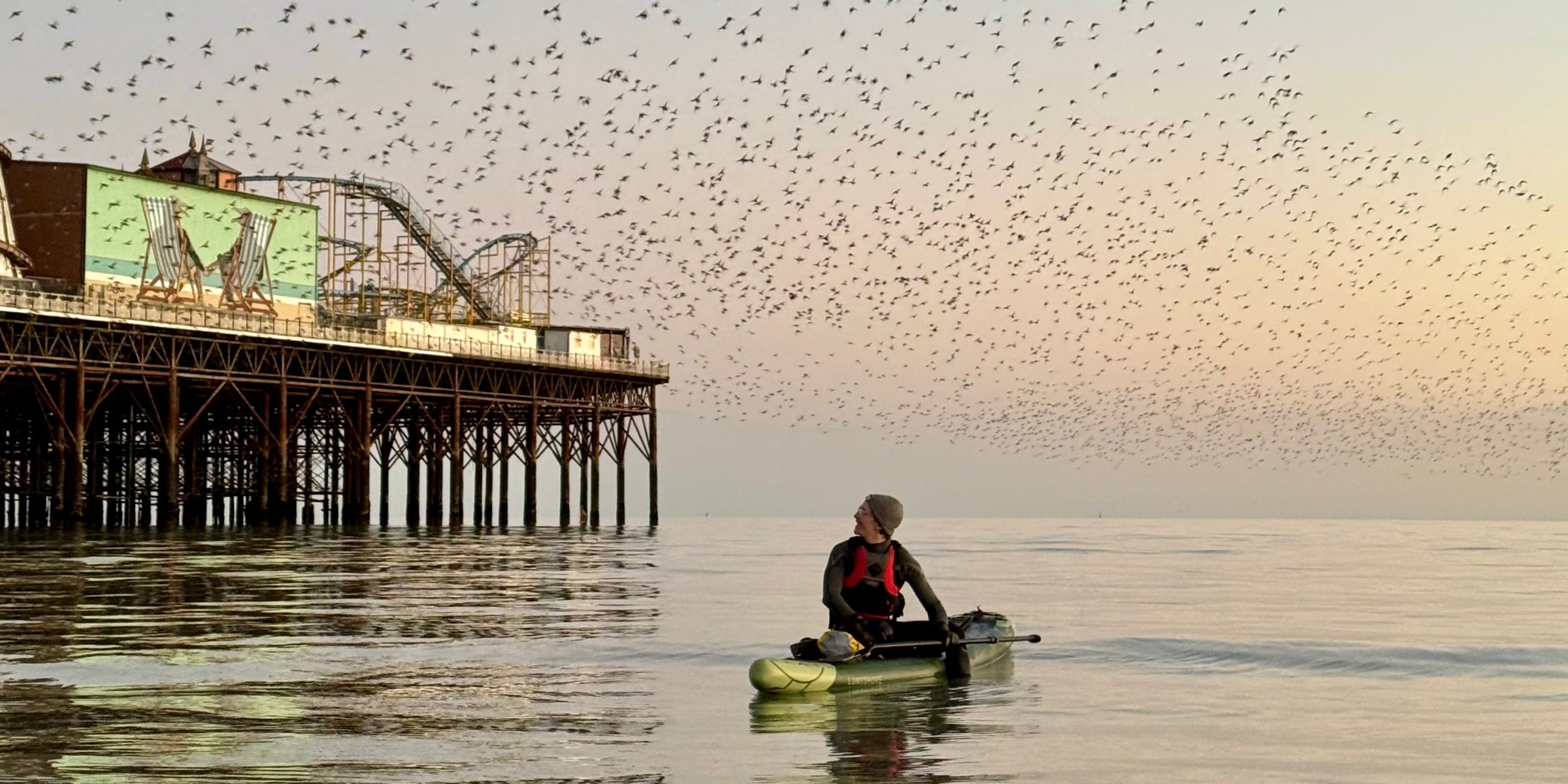 Paddleboarding next to a pier