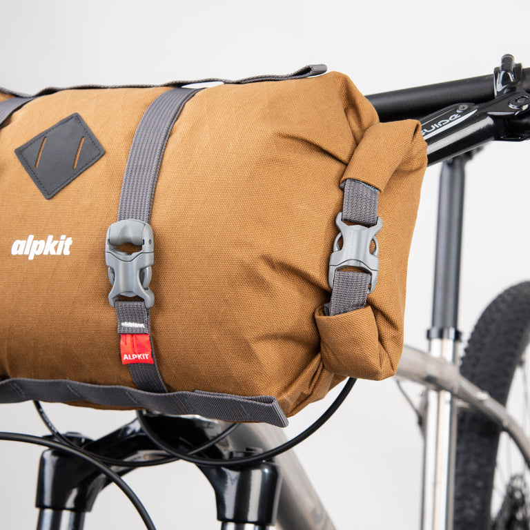 alpkit kuoka handlebar bag for bike packing in mountain brown roll top