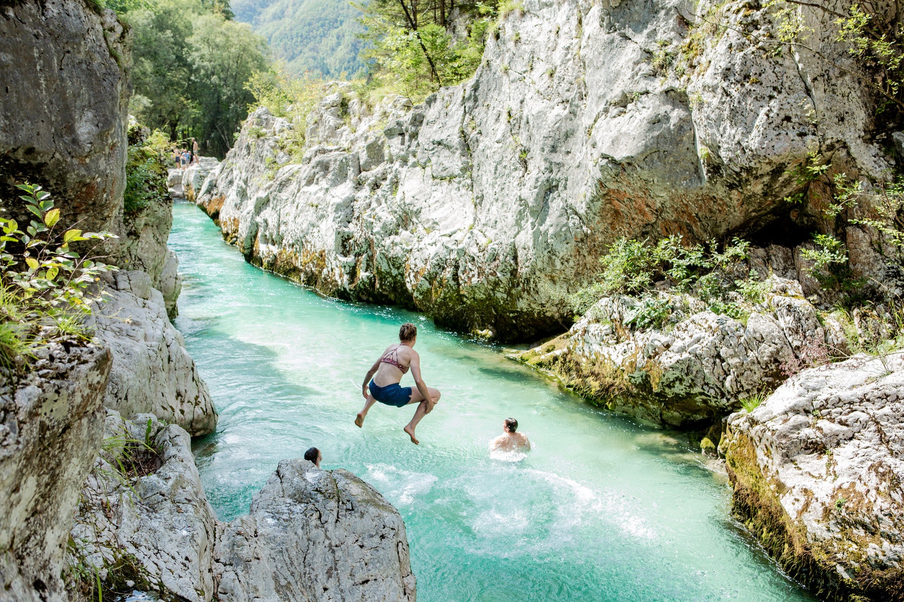 Woman jumping into mountain river