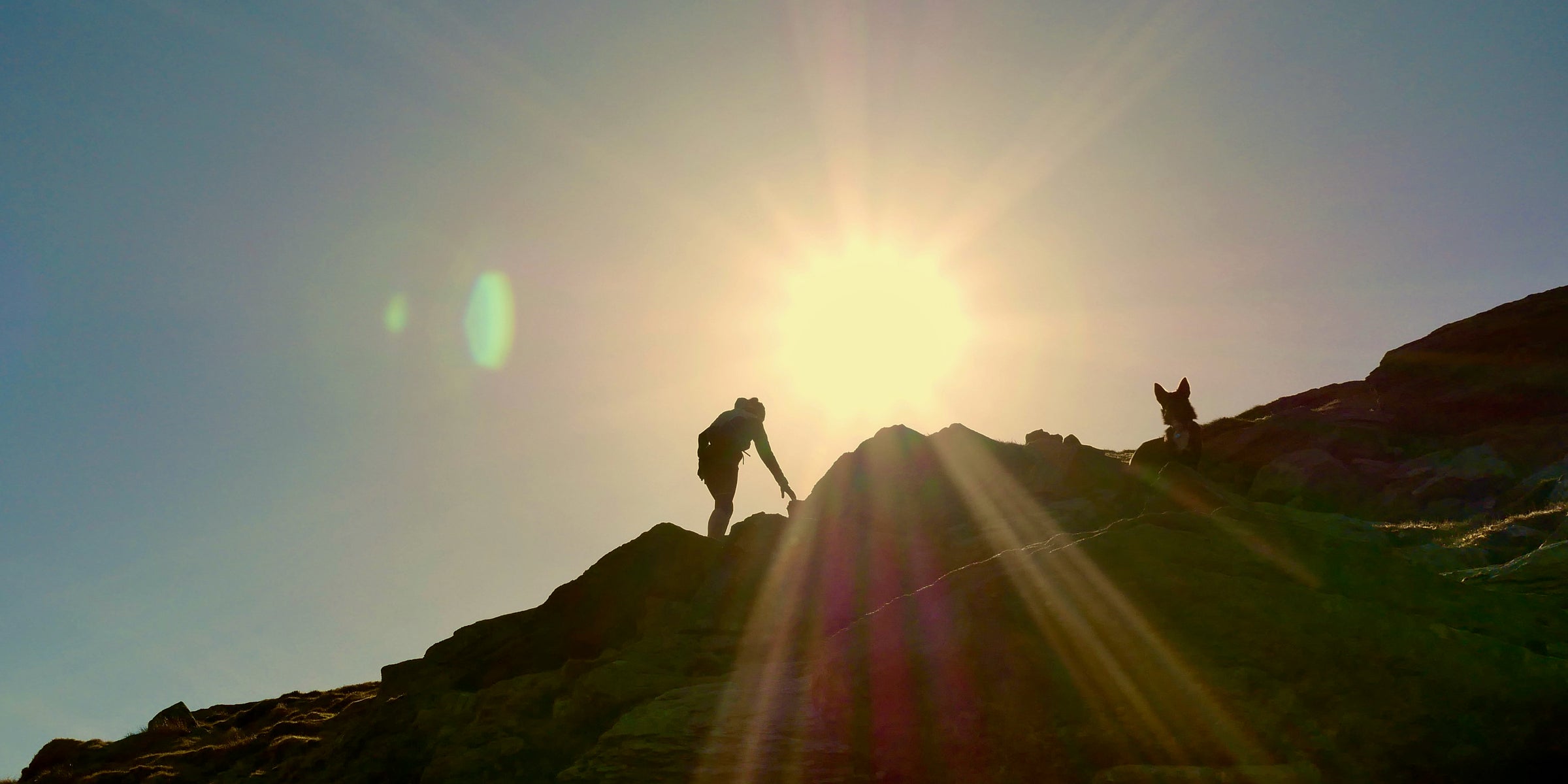 Walking up steep mountain side with the sun setting
