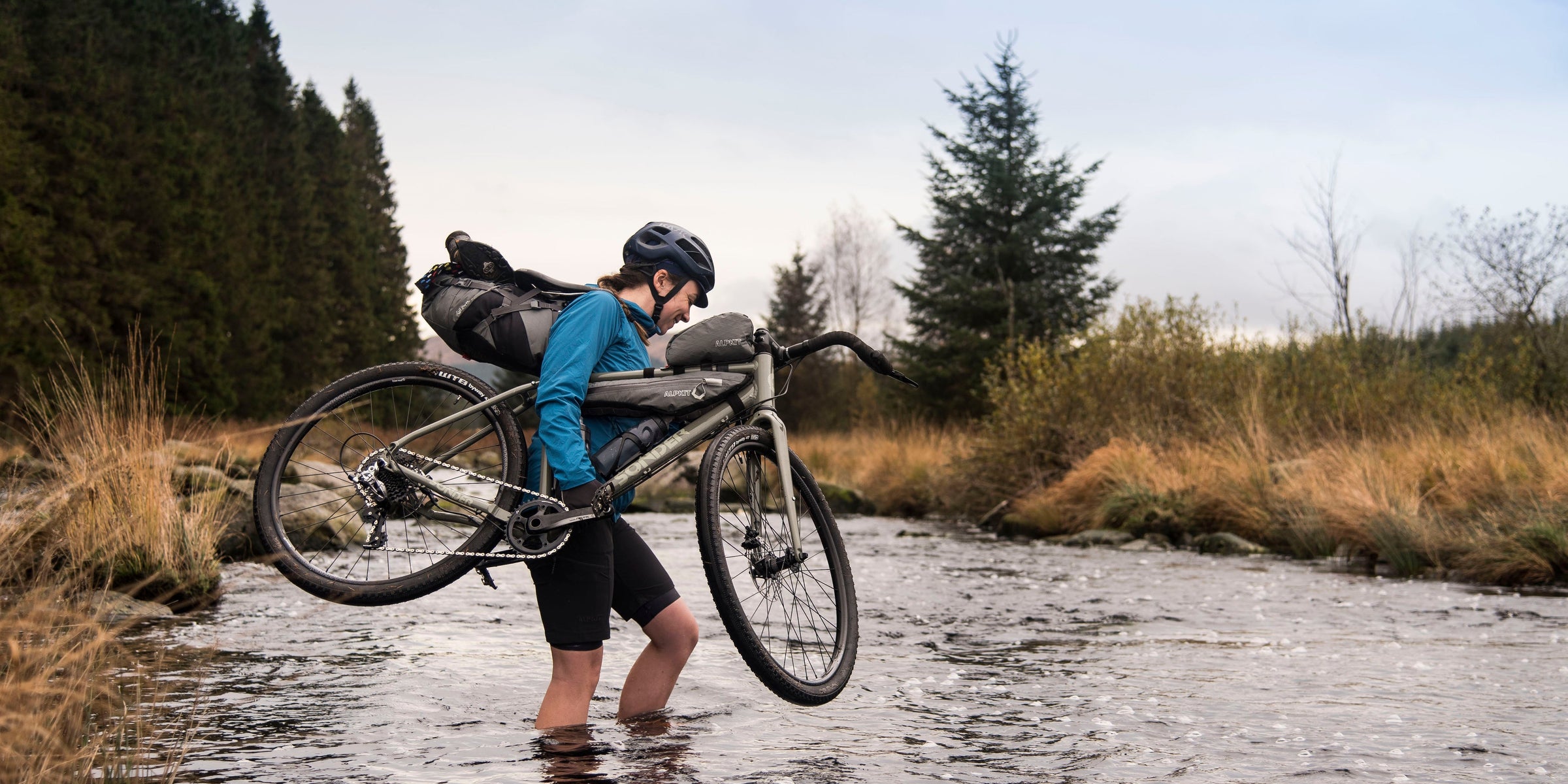 Fording a river with a gravel bike on a bikepacking adventure