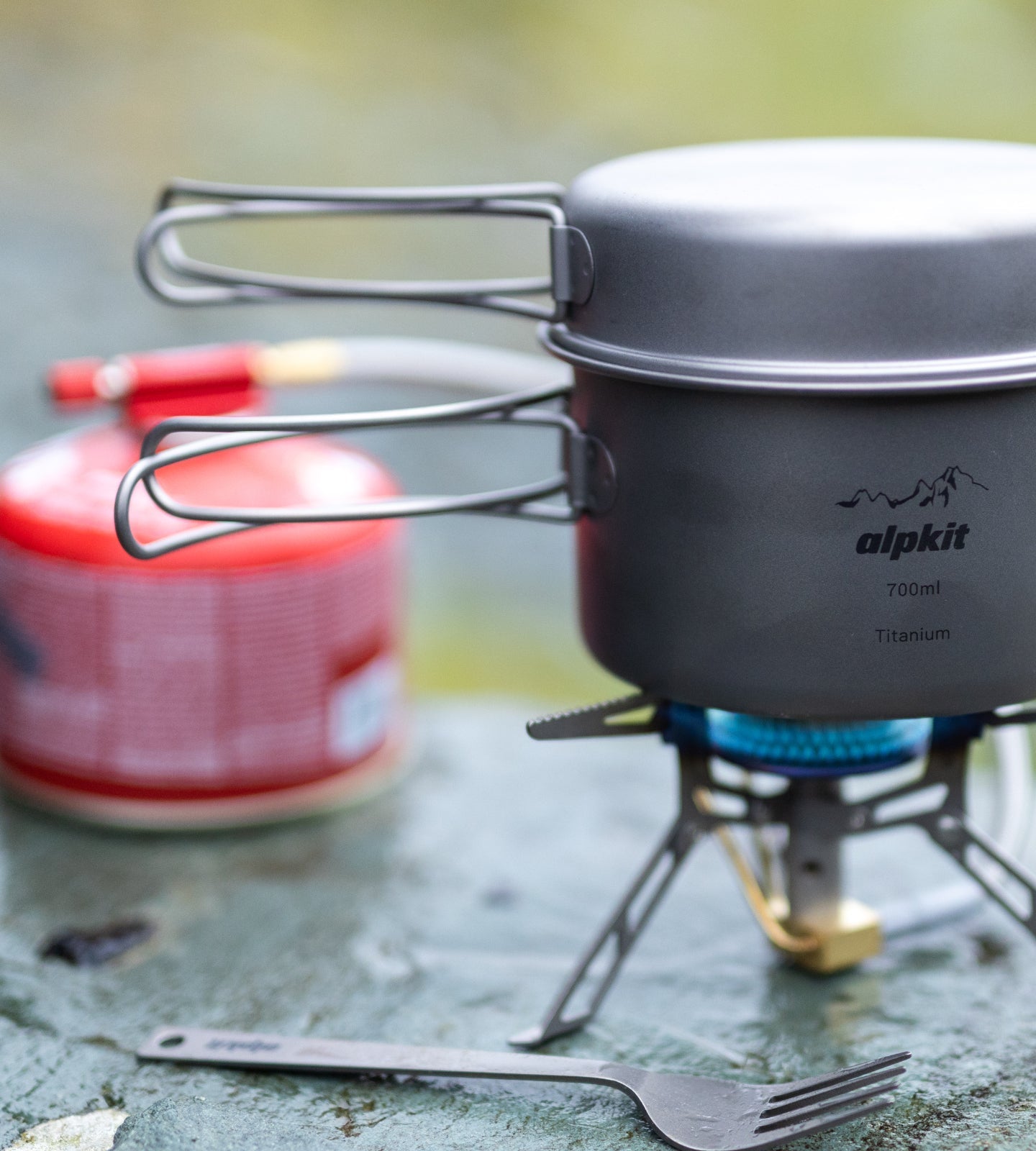 Lightweight camping stove boiling water on a stone wall