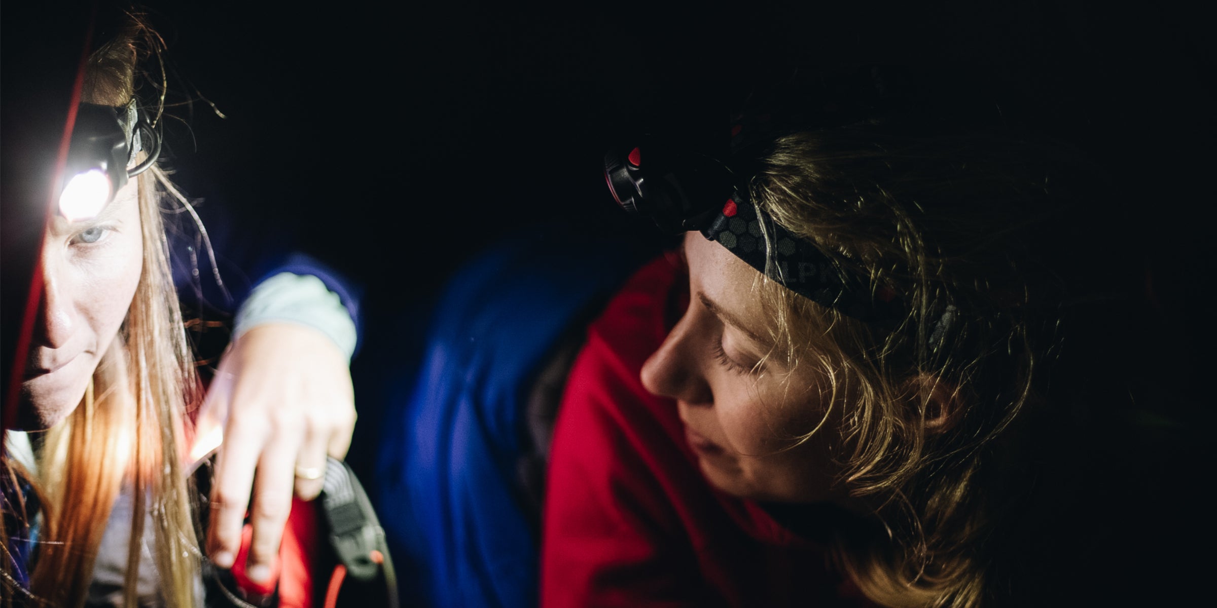 2 campers on an expedition wearing head torches
