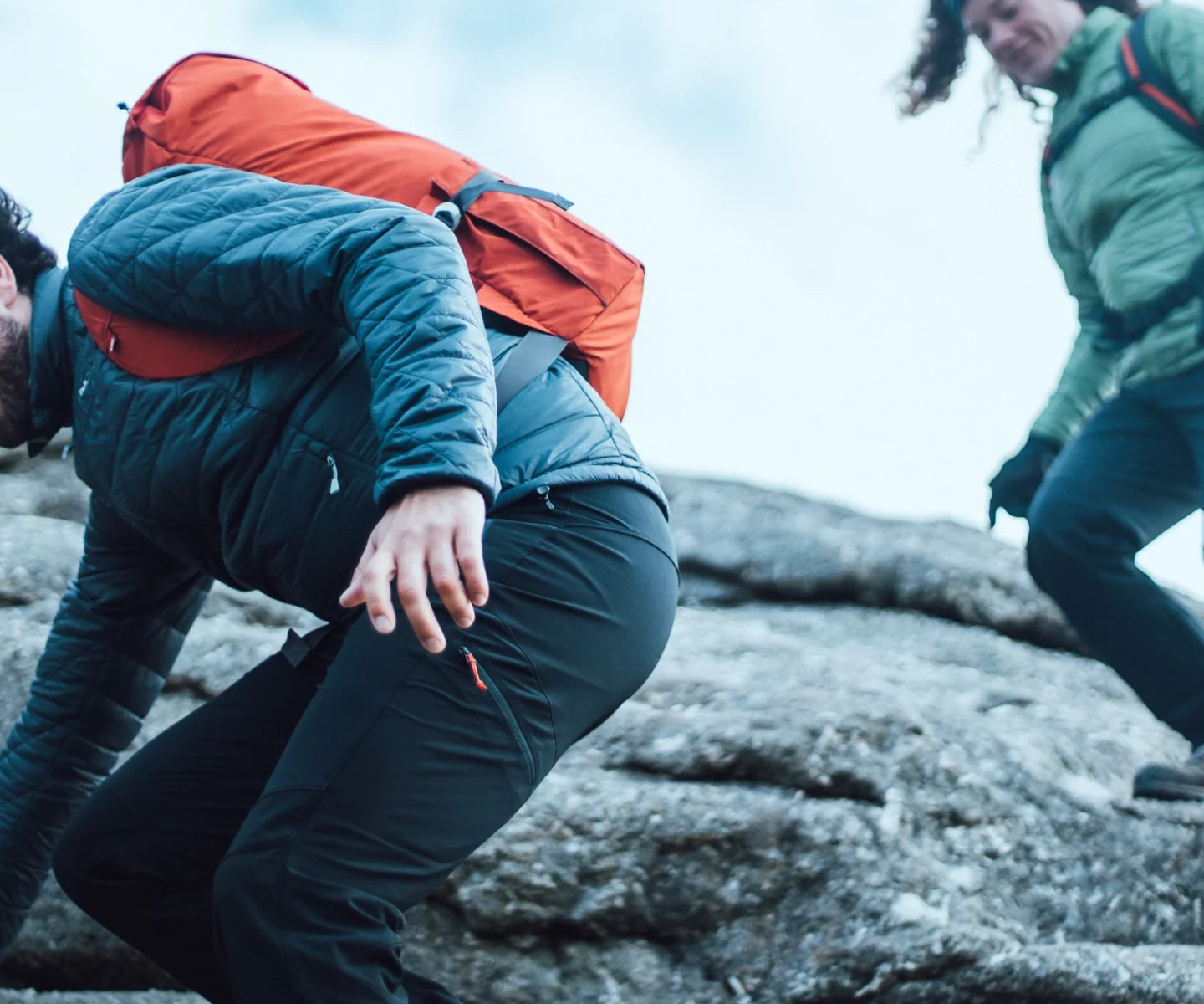 Hikers descending rocky slabs