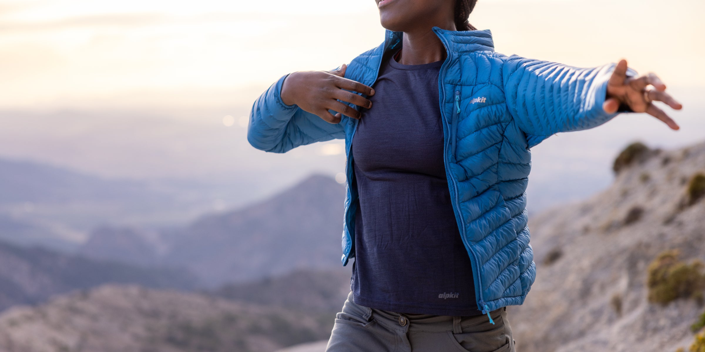 Throwing on a lightweight down jacket on a summit