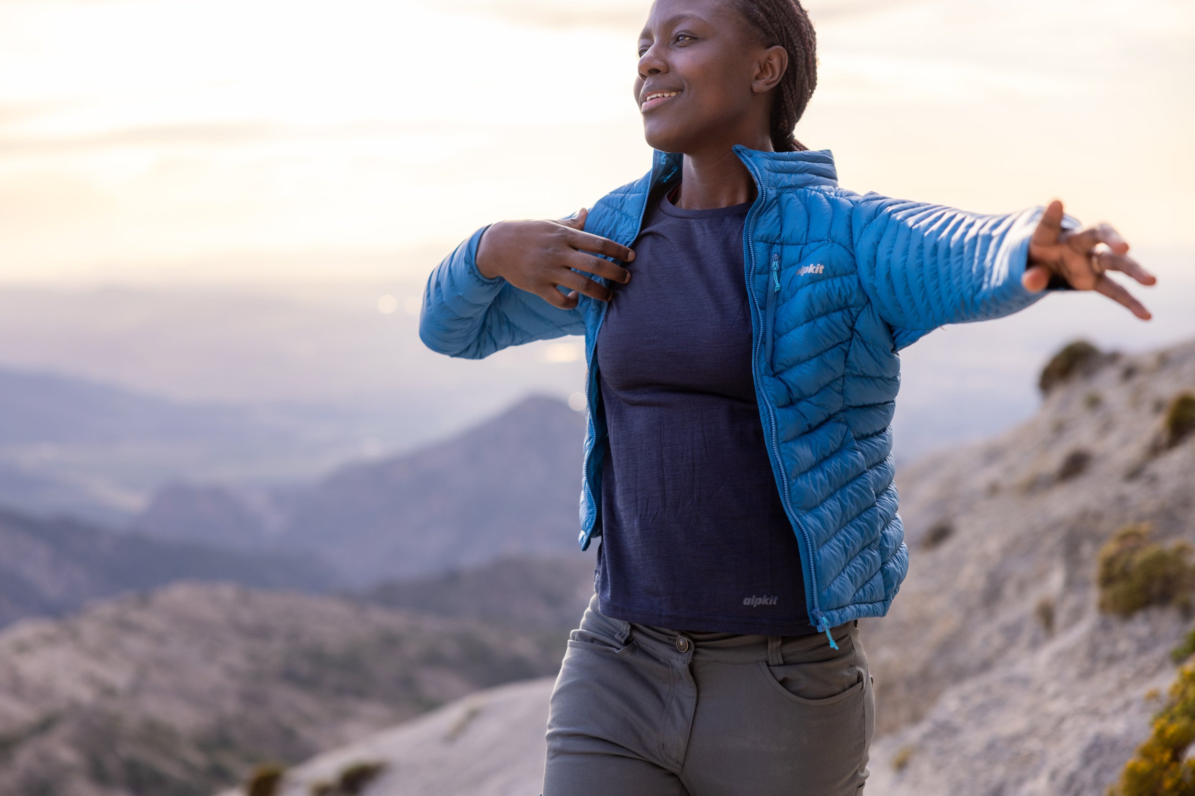 Throwing on a lightweight down jacket on a summit