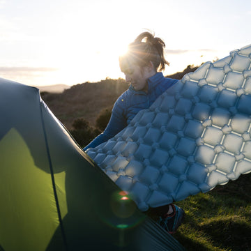 Preparing a camping mat for sleeping on the snow