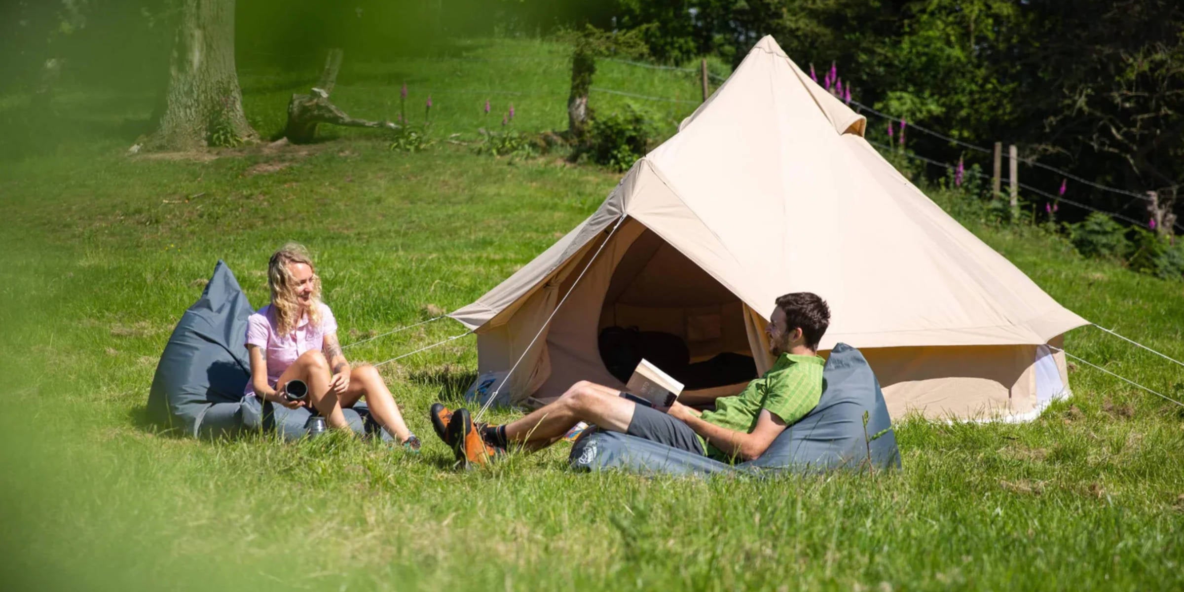 Campers sitting outside a bell tent