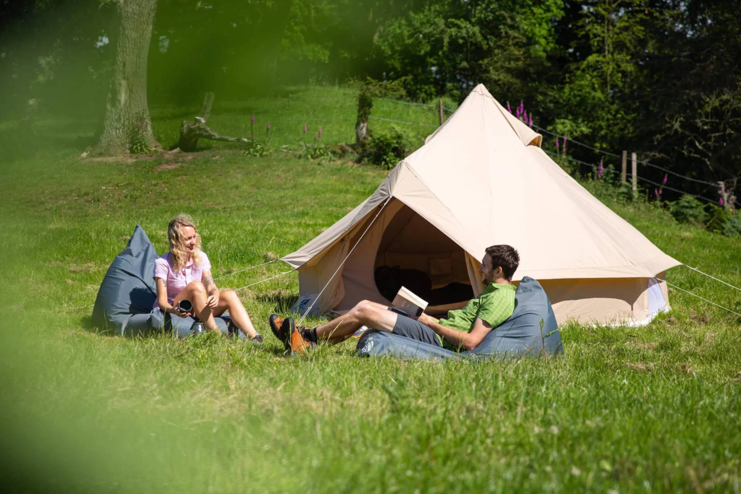 Campers sitting outside a bell tent