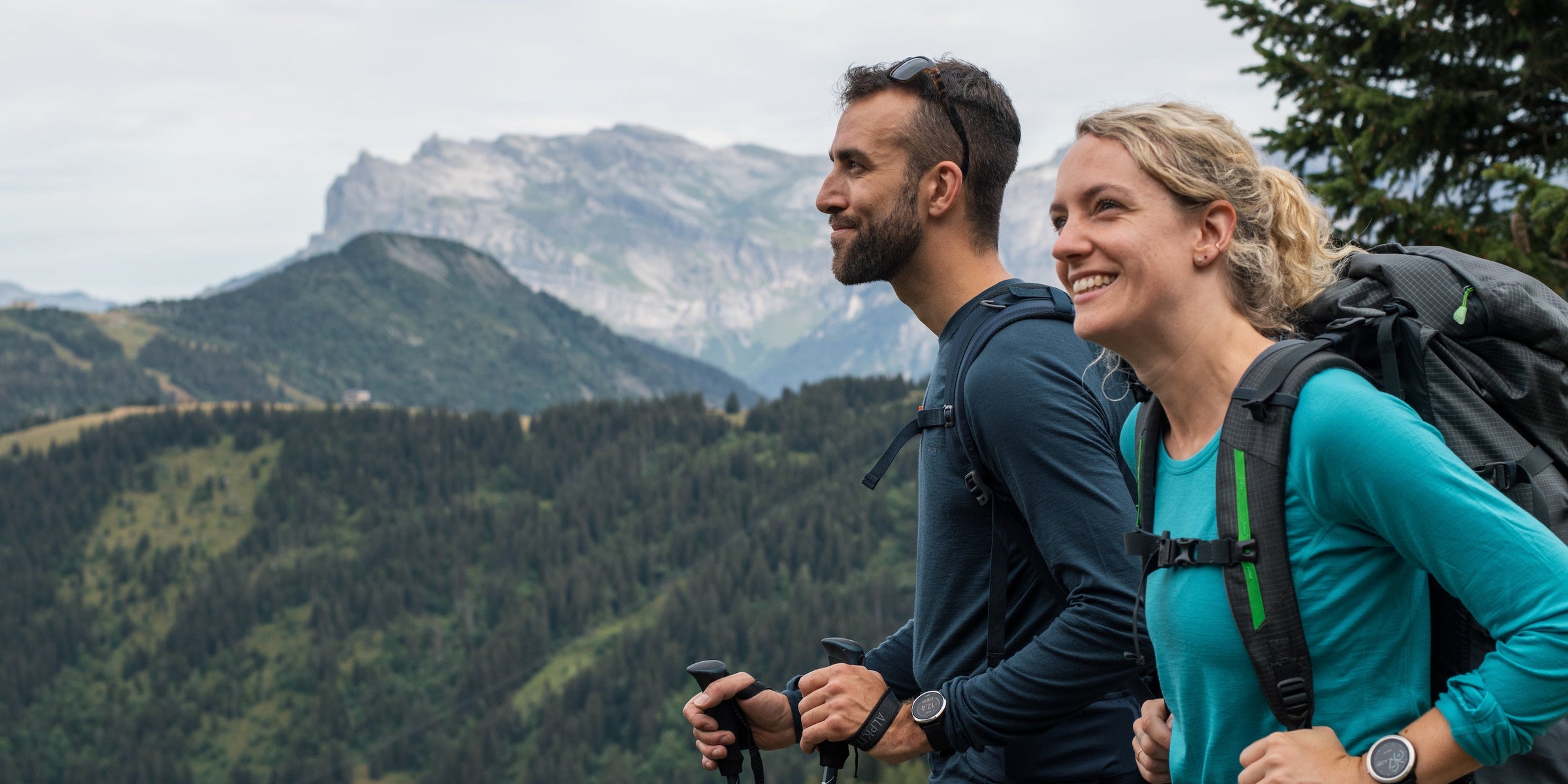 A man and a women trekking in Merino wool base layers in the French Alps