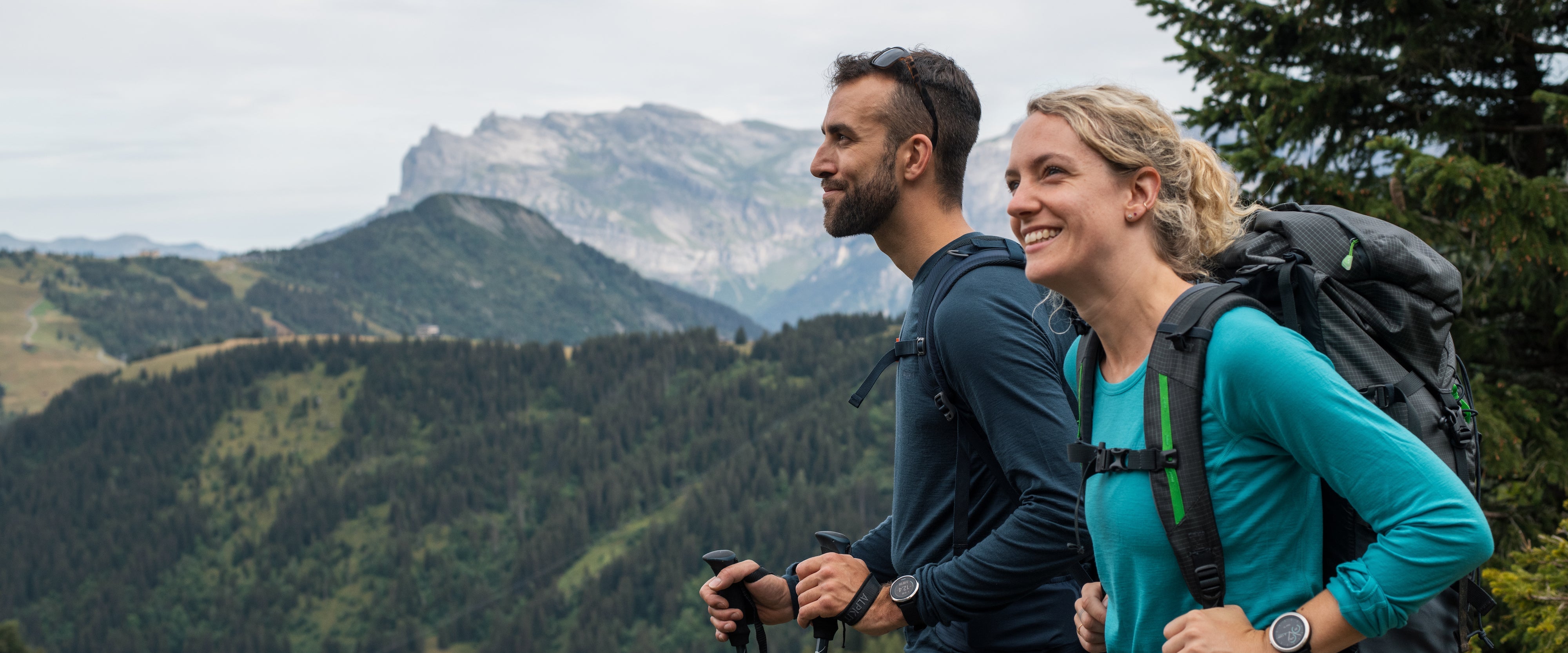 A man and a women trekking in Merino wool base layers in the French Alps
