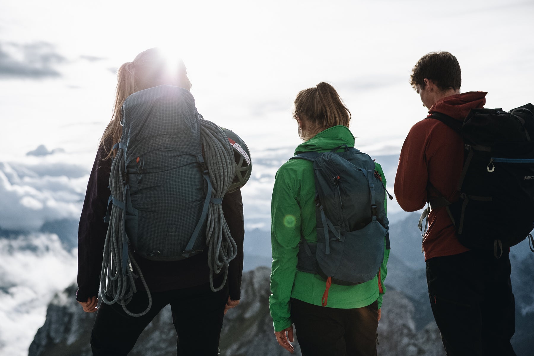 Hikers wearing different sized rucksacks atop a mountain