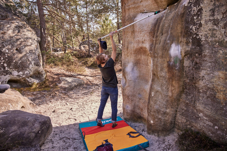 Zofia Reych cleaning the rock of chalk in Font with the Origin bouldering mat - action - closed