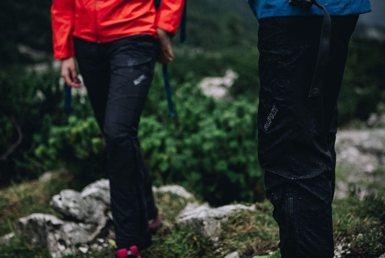 the legs of a man and woman outside in the rain wearing waterproof trousers - action - closed