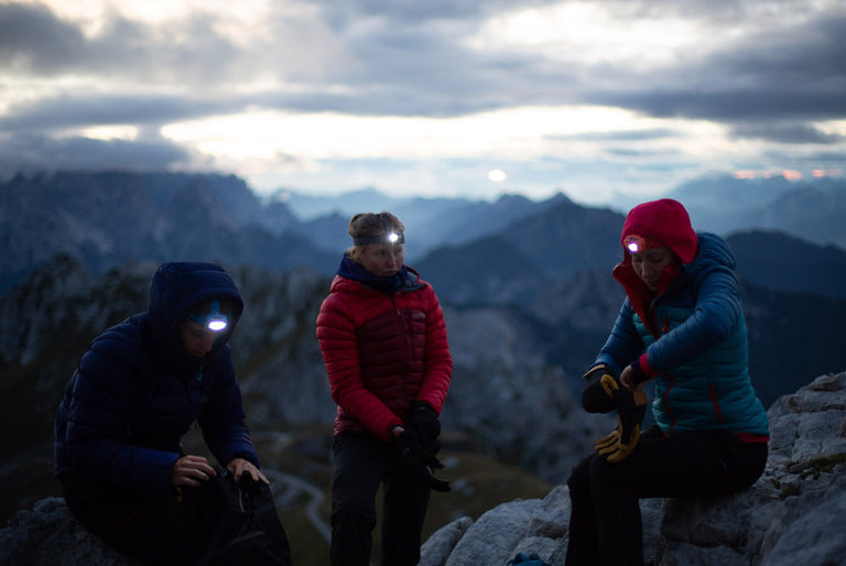 Group using Alpkit head torches in the mountains - action