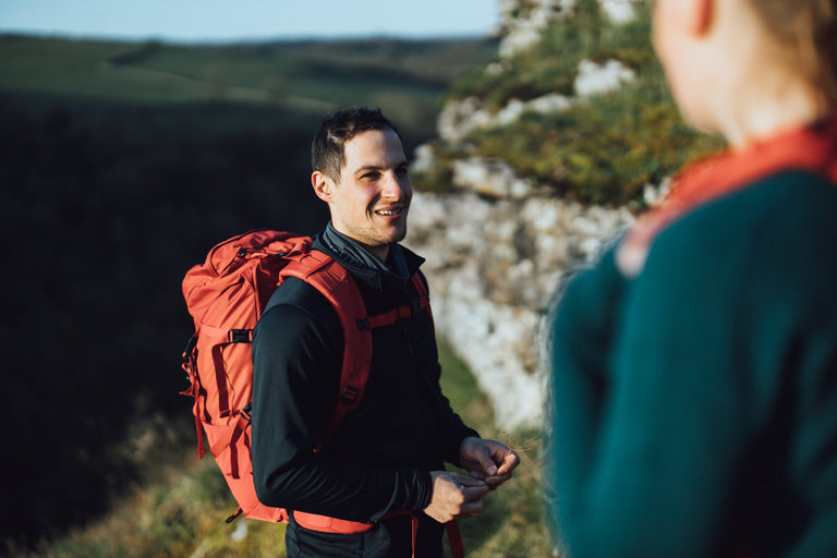 A man hiking in the Peak District in a black fleece jacket - action - closed