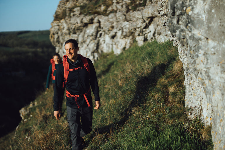 A man hiking in the Peak District in a black fleece jacket - action - closed