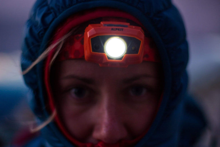 Woman using Alpkit Viper head torch - action